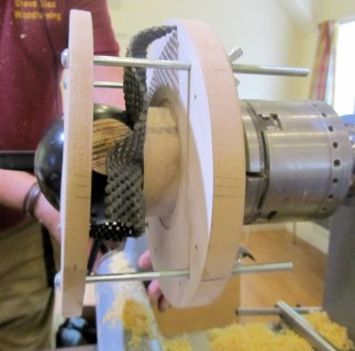 Jig used to hold a sphere while turning decorative features on the side